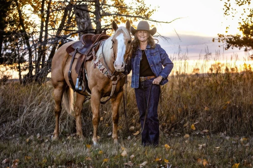 palomino horse with lady in grey hat in central Nebraska pasture