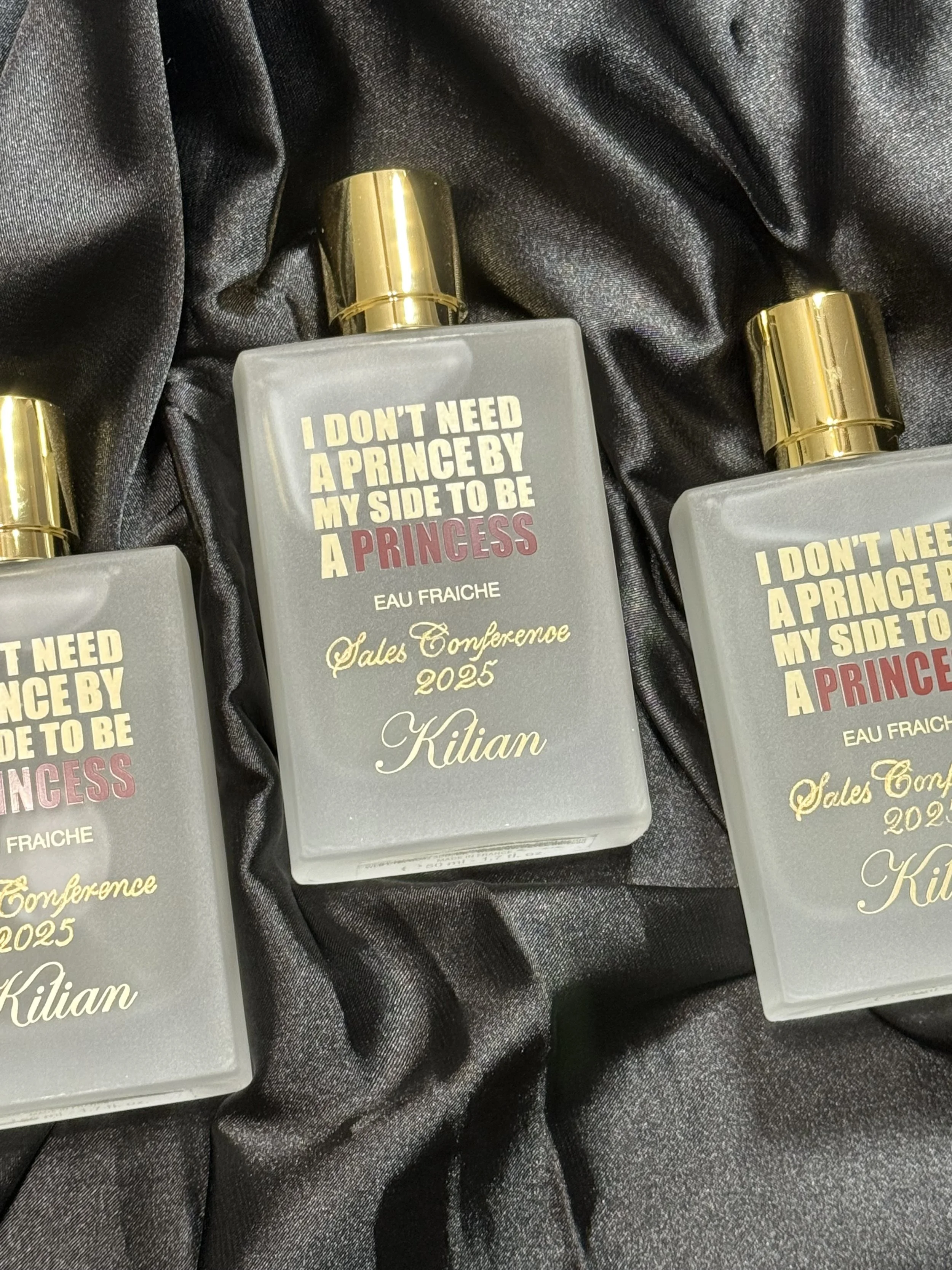 three perfume bottles engraved in gold calligraphy "Sales Conference 2025" Kilian Paris