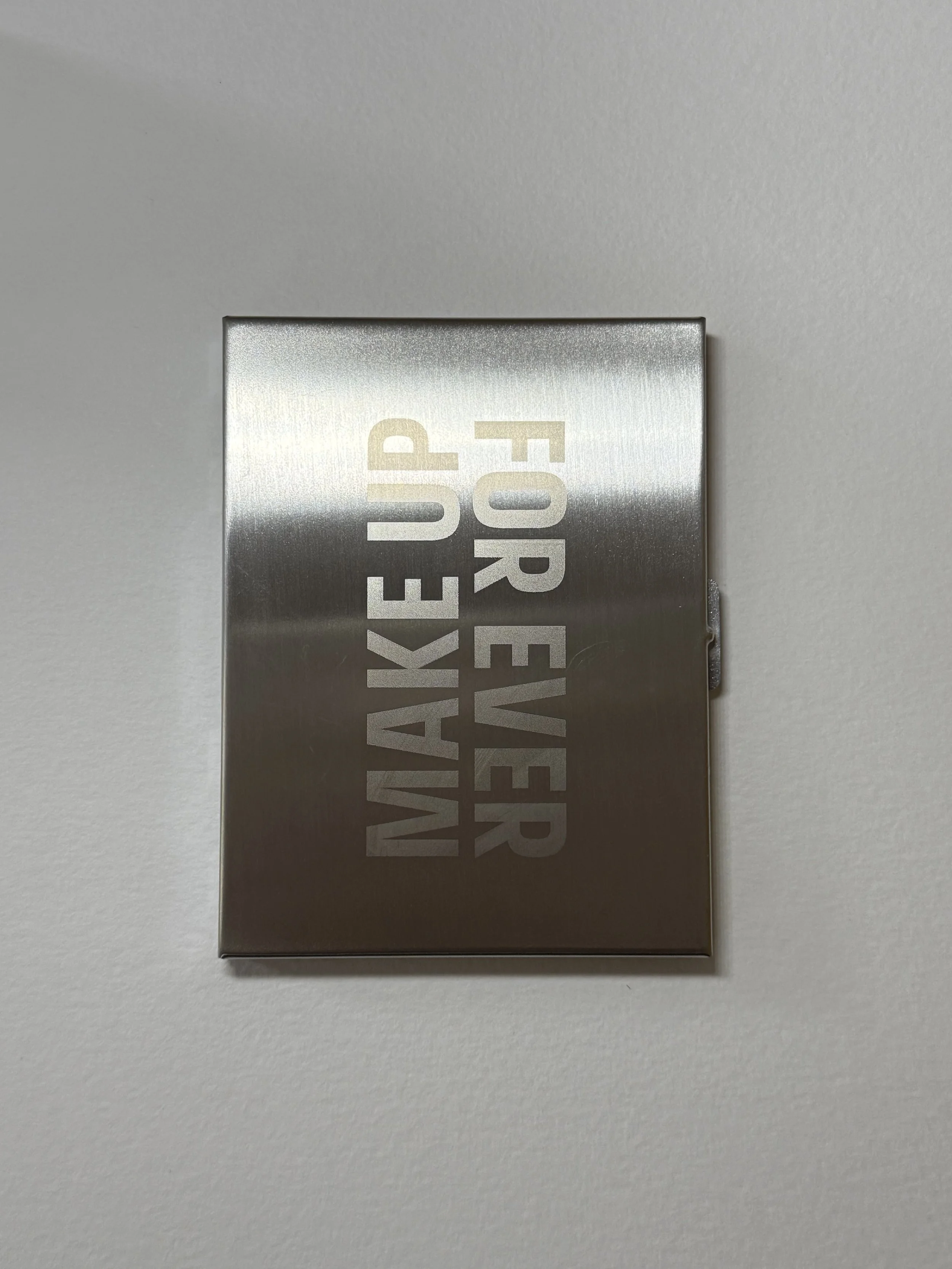 Silver metal case engraved with Make Up For Ever logo for brand event