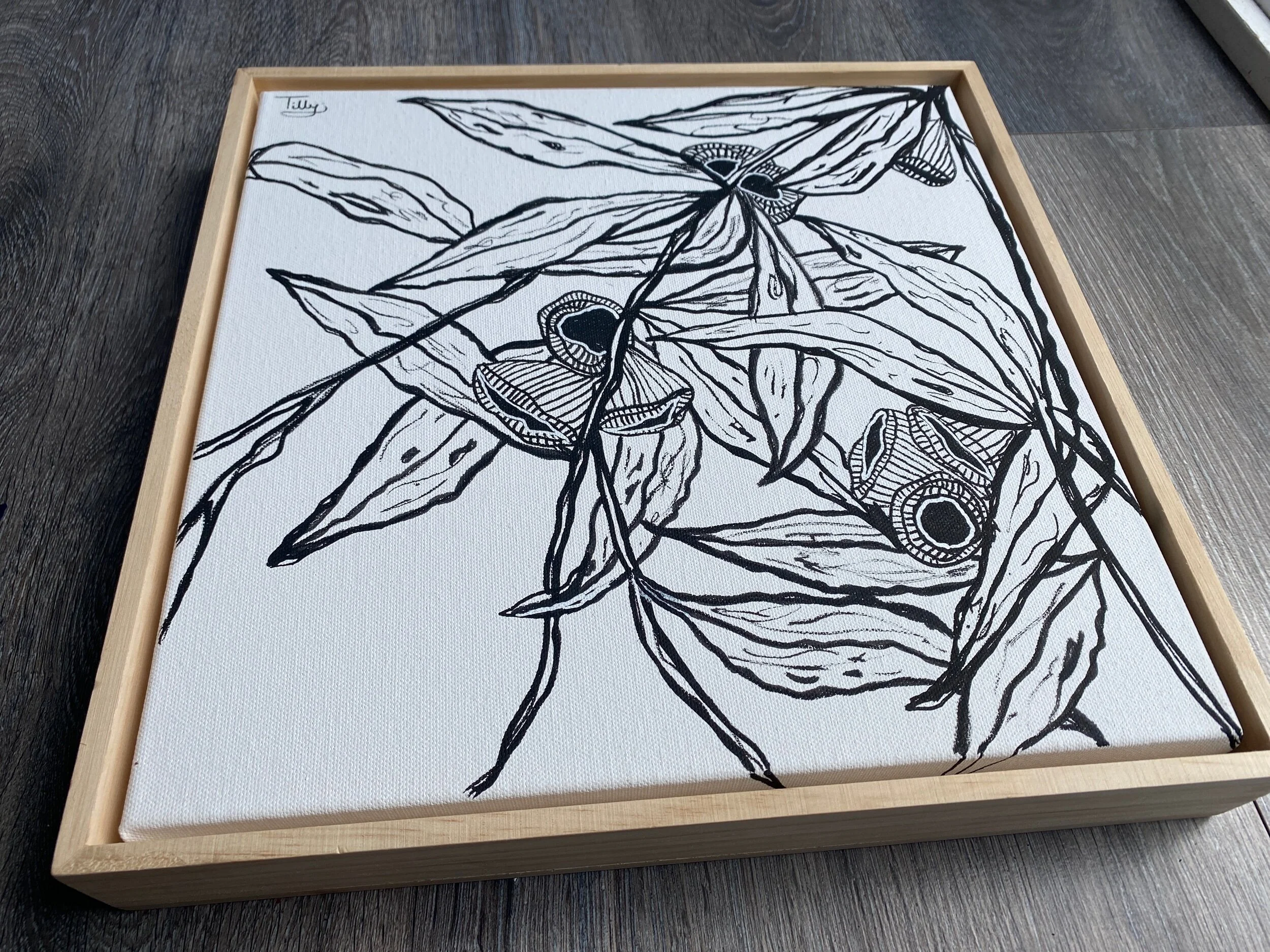 Black and white botanical illustration on canvas with wooden frame, featuring leaves and abstract floral shapes.