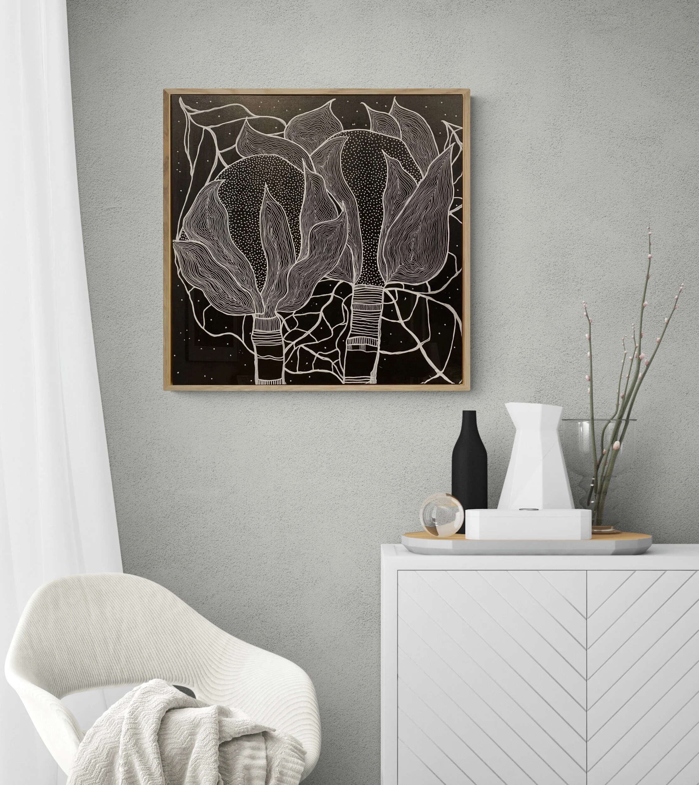 Interior scene with modern abstract black and white artwork on the wall above a white cabinet. The cabinet has decorative items, including a black vase and a white geometric vase. A light-colored chair with a textured fabric is positioned nearby, wit