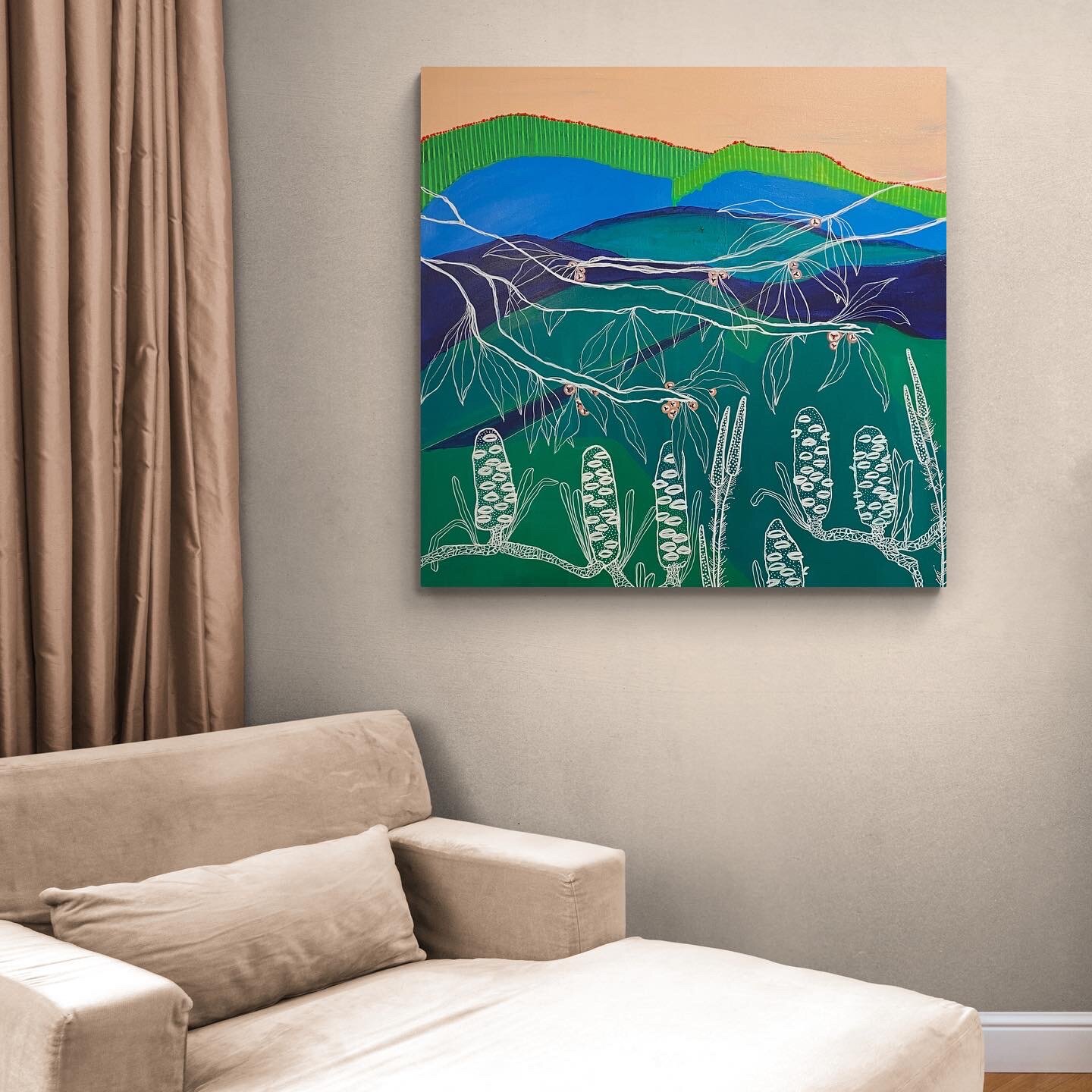 Modern abstract painting with colorful landscape, including greens, blues, and a beige sky, featuring stylized plants. It's hung on a wall above a beige sofa with a pillow, next to curtains.