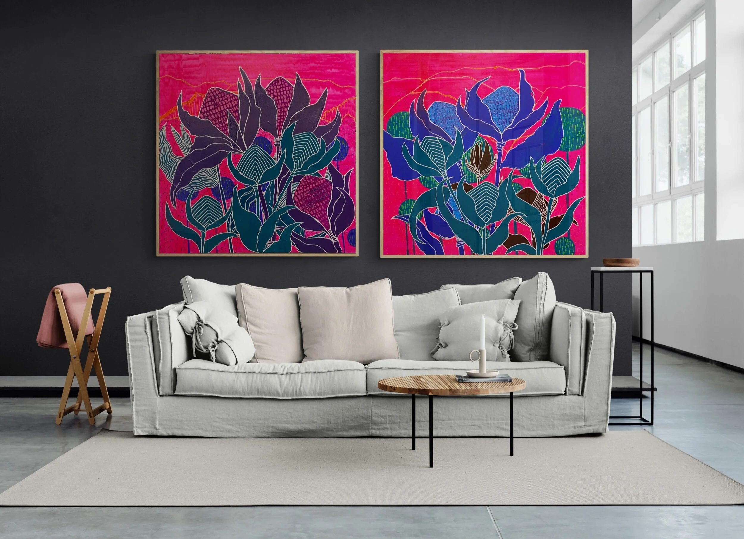 Modern living room interior with a white sofa, round wooden coffee table, and two colorful abstract paintings on a dark wall. A window provides natural light.