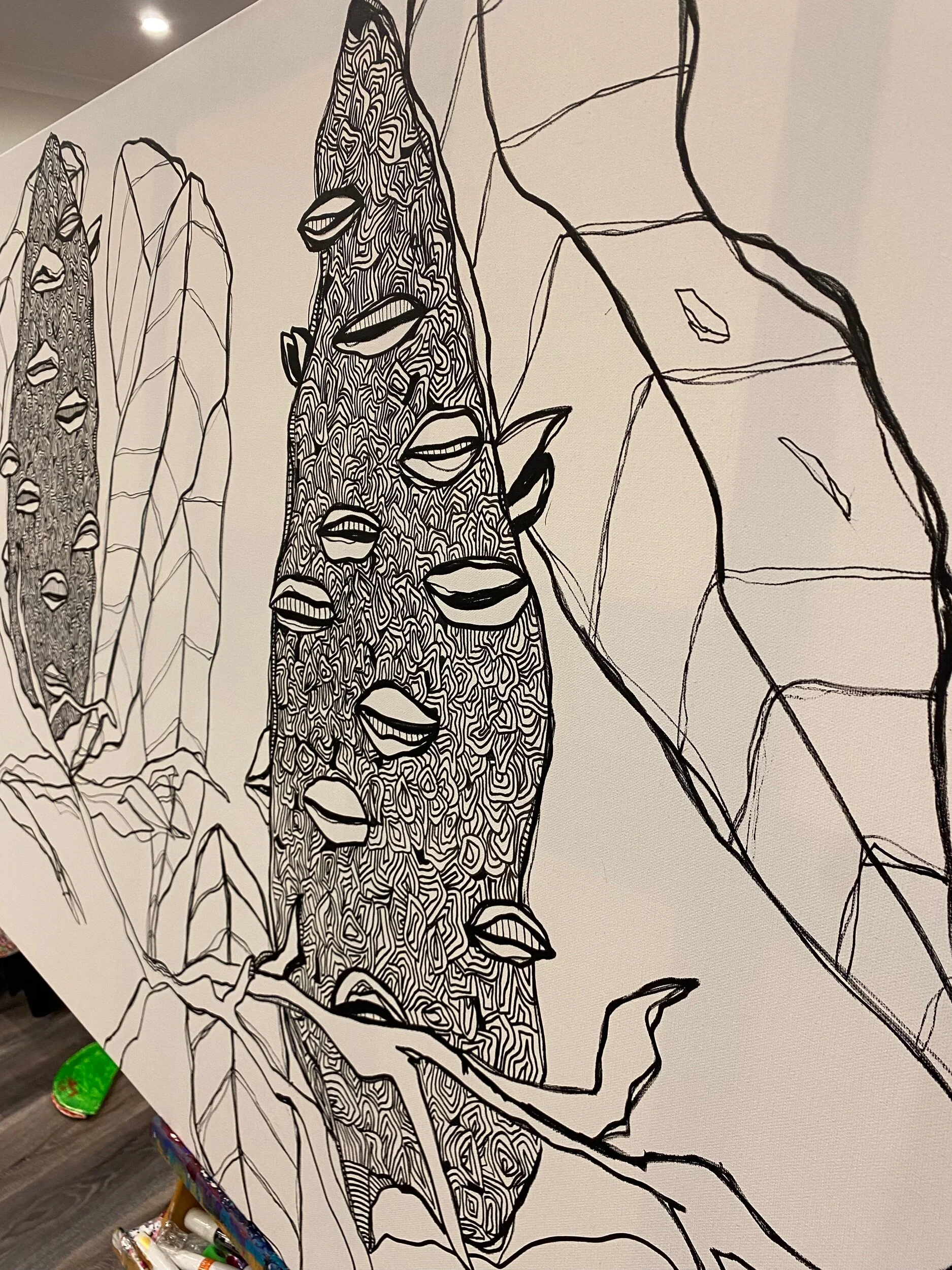 Black and white line art featuring abstract shapes with intricate patterns and leaf-like elements, resembling stylized plants or cactus forms on a canvas or paper.