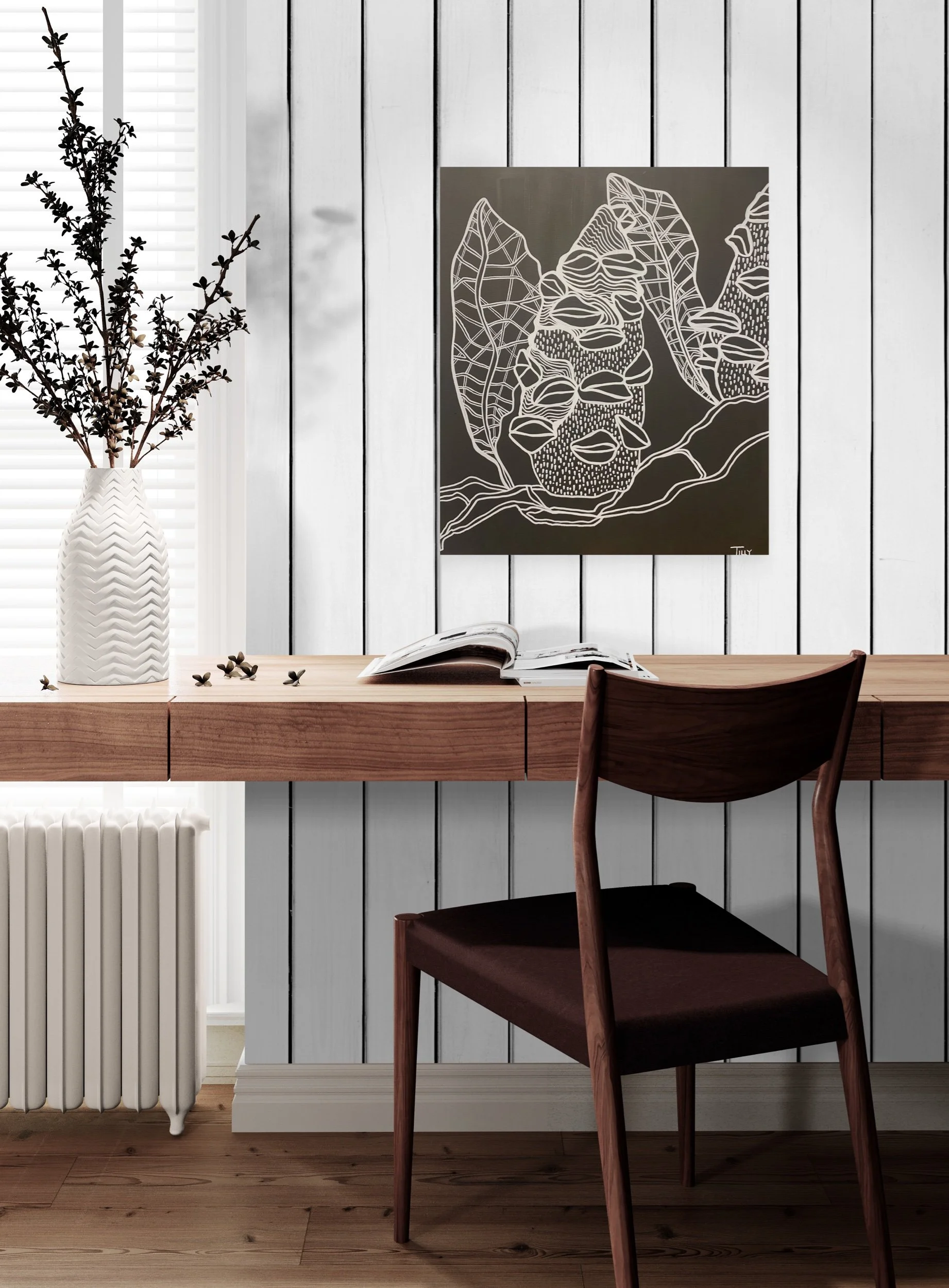 Interior view of a desk with a book, a decorative vase with branches, and a wall art piece depicting fruit and leaves. There's a wooden chair in front of the desk, a radiator below it, and a window with blinds to the left.