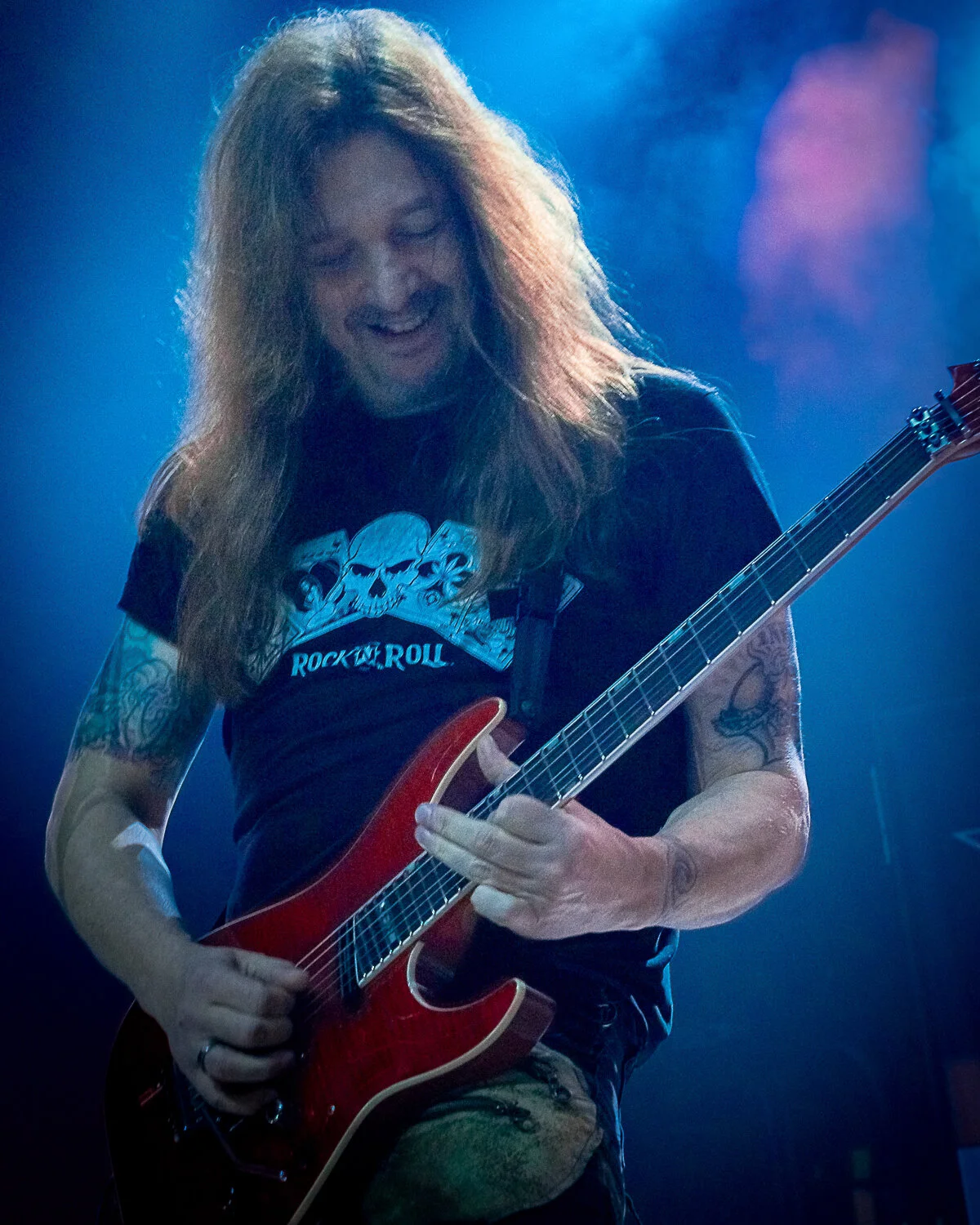 Dave “Snake” Sabo grinning as he plays a red guitar, Skid Row live in concert at The O2 Forum Kentish Town, January 2019