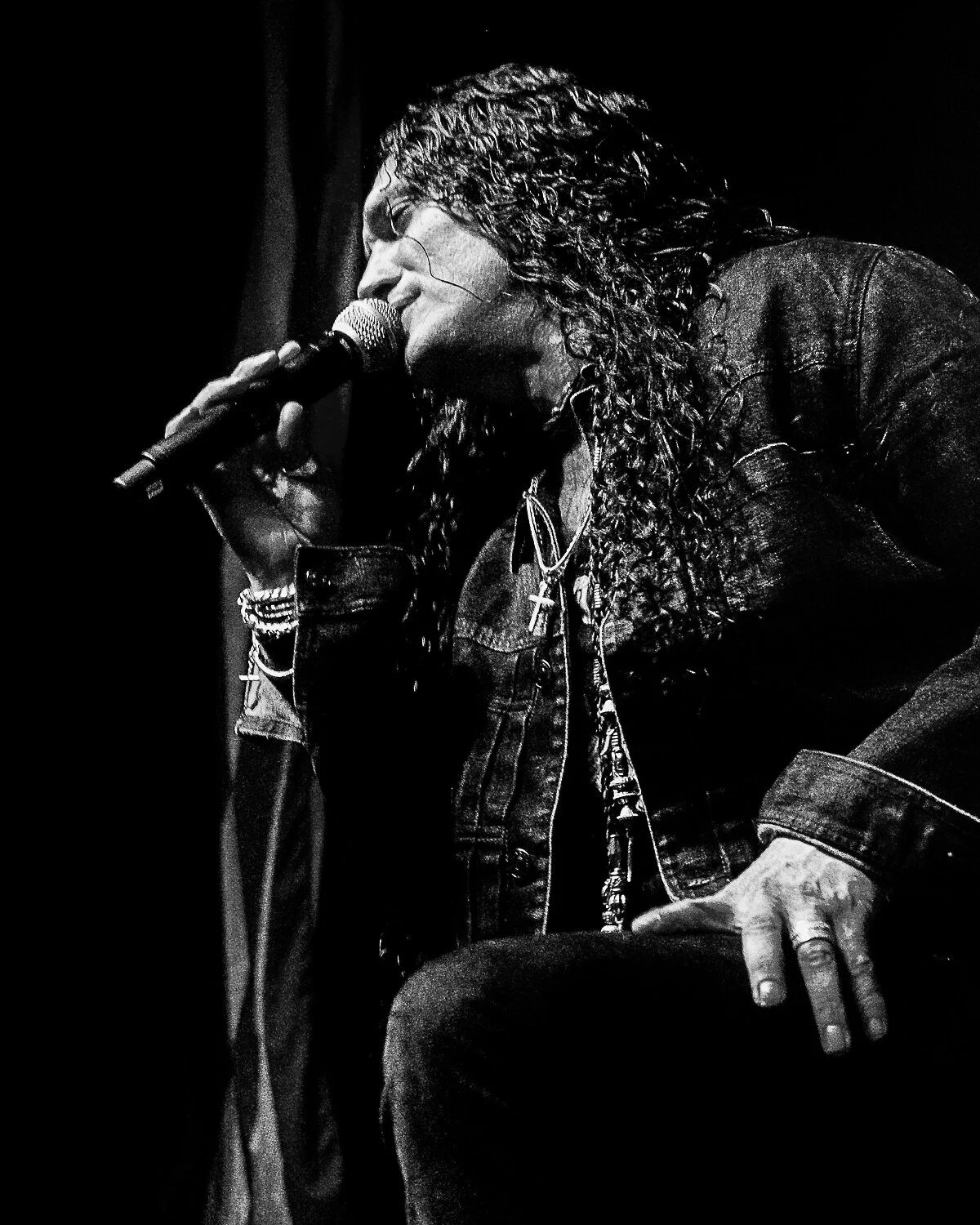 ZP Theart crouching at the front of the stage with a microphone, Skid Row live in concert at The O2 Forum Kentish Town, January 2019
