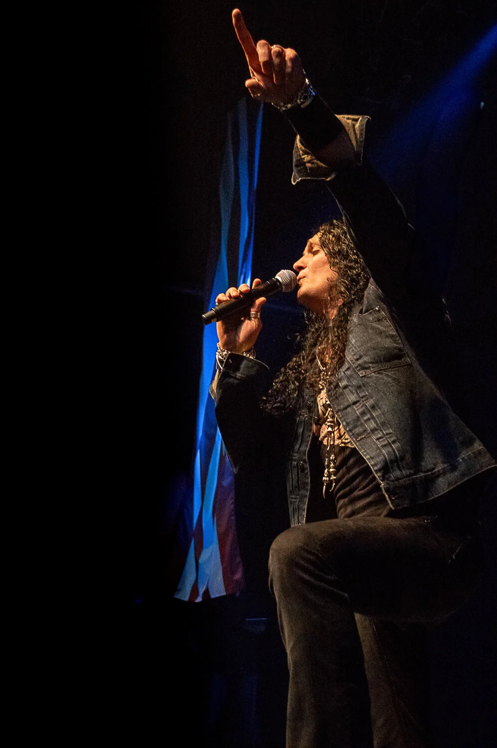 ZP Theart pointing upwards as he sings, beside a US flag, Skid Row live in concert at The O2 Forum Kentish Town, January 2019