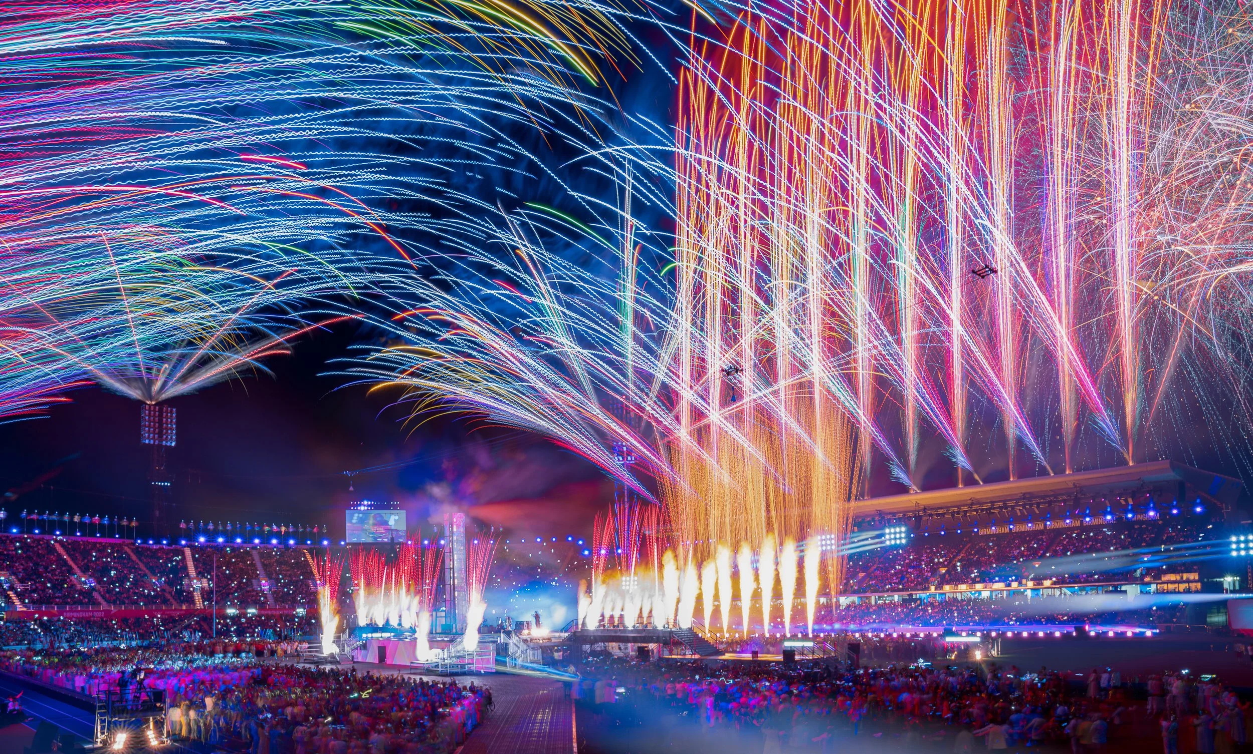 aFireworks and light beams over the crowd at the Closing Ceremony of the Birmingham 2022 Commonwealth Games, Alexander Stadium