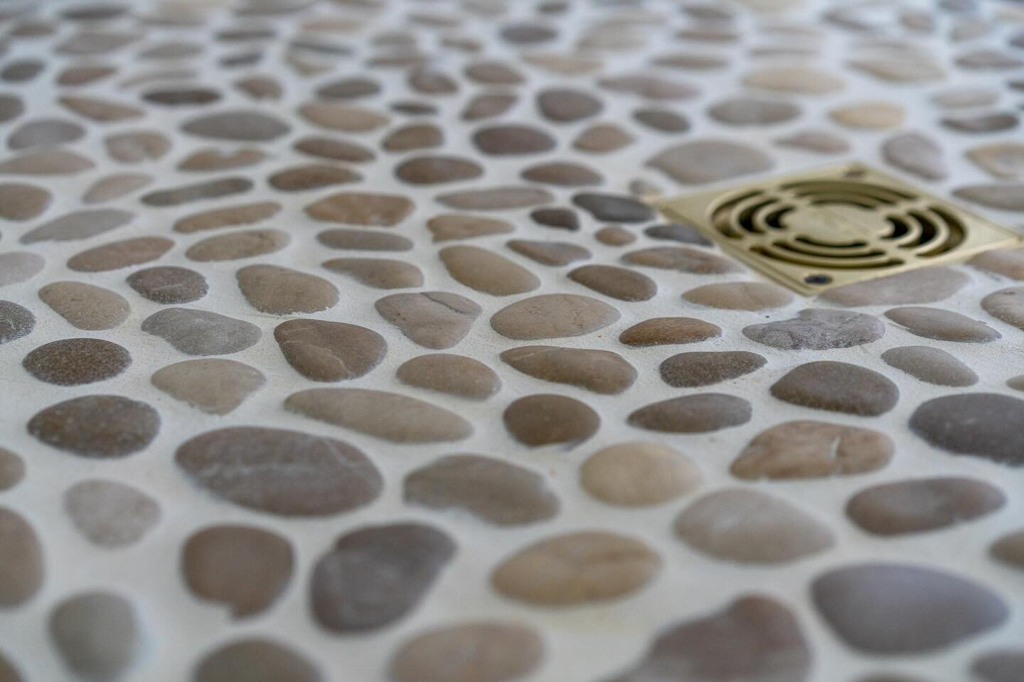 Does anything say beach cottage like a stone pebble shower floor?  #builder #homebuilder #waterfrontliving #northport #leelanau #traversecity