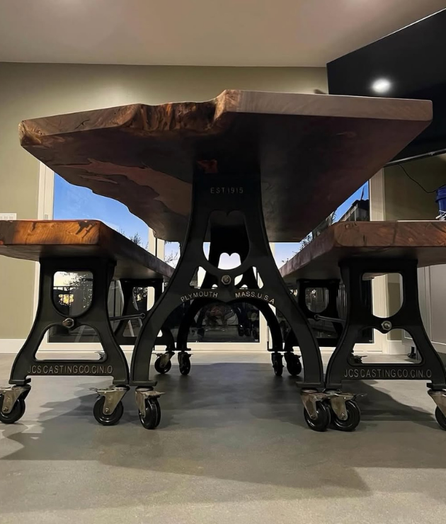 JCS Casting Co. cast iron dining table bases with caster wheels supporting a live-edge wood top