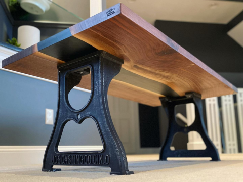 JCS Casting Co. black cast iron coffee table legs supporting a live-edge walnut top in a living room