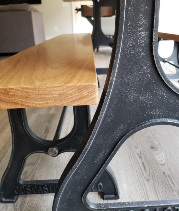 Rustic Black cast iron bench legs under a wood top beside a matching dining table base