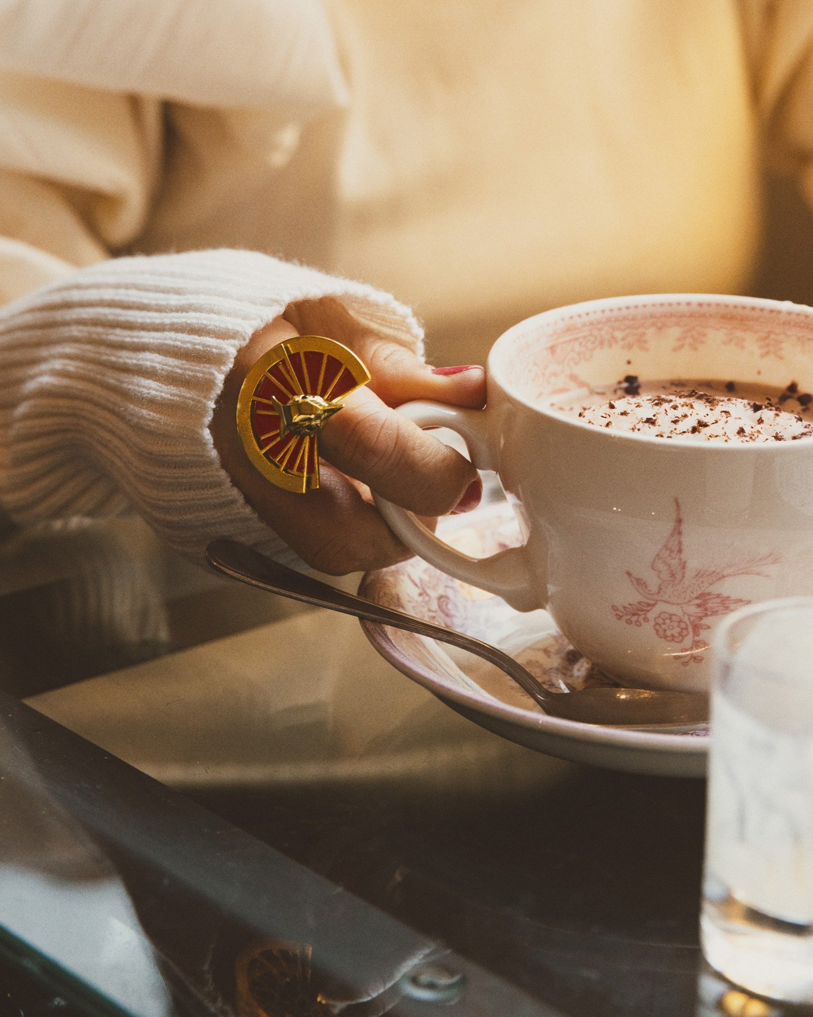 Savoring the little moments in Rouen, with a warm cup and a bold touch of the Flycatcher ring. This piece brings a touch of wild beauty to even the calmest settings. #ElenaMatallana #FlycatcherRing #TropicalChic #JewelryDetails #CozyMoments