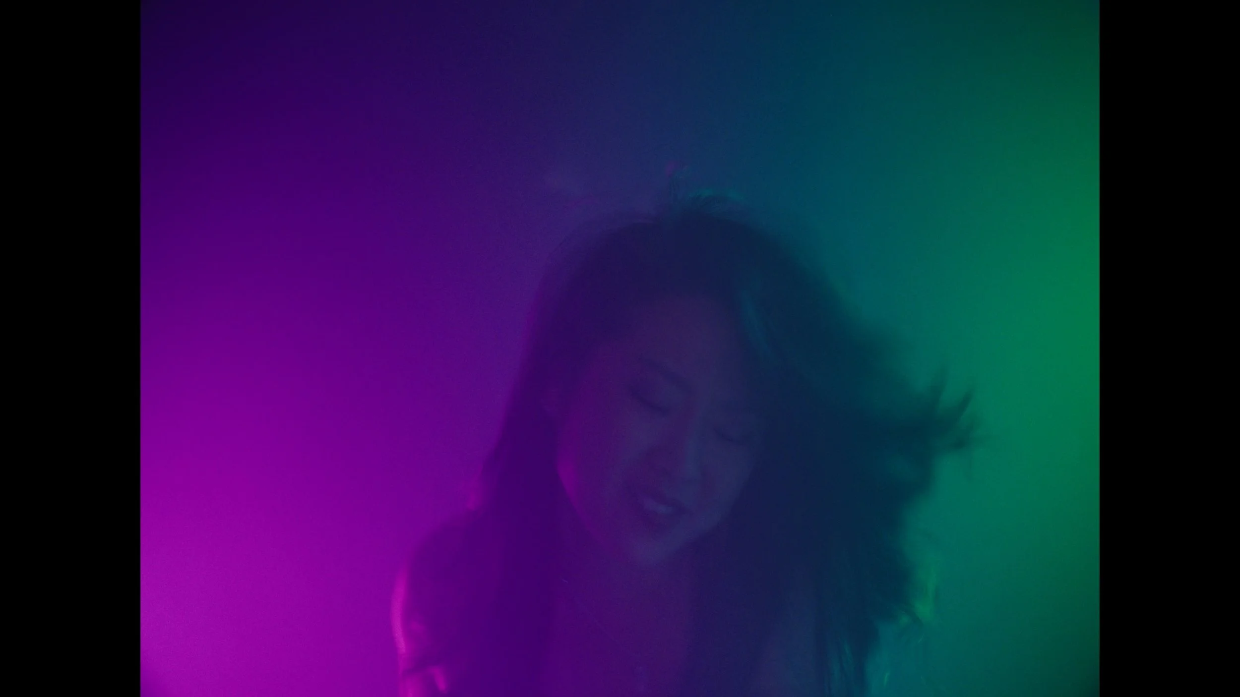 cinematic still frame from indie film, Openers, woman washed in green and magenta stage lights rocks out while playing show