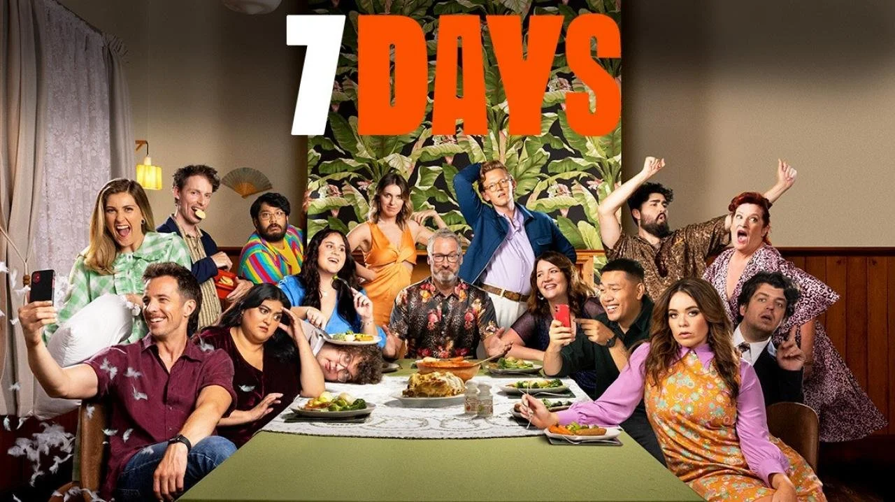Group of people at a dinner table with a floral background, "7 Days" text at the top, exhibiting various expressions and activities, including a person taking a selfie, another person eating, and several looking surprised or amused.
