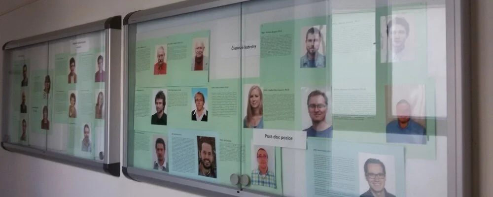 Display boards with photographs and biographies of various people, likely in an office or educational setting.