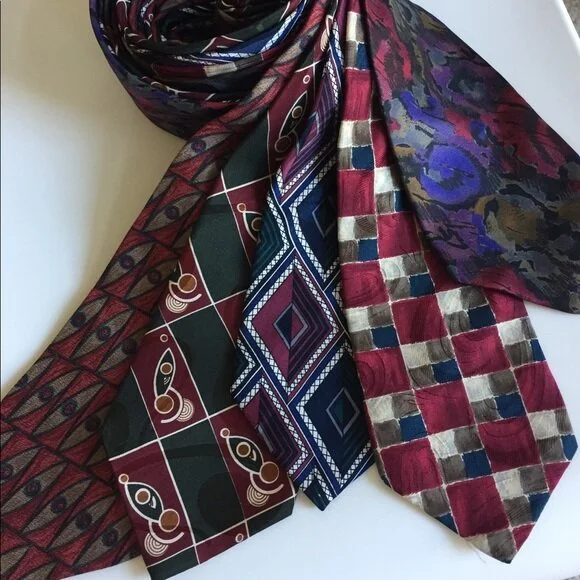 Four colorful patterned scarves intertwined on a white surface.