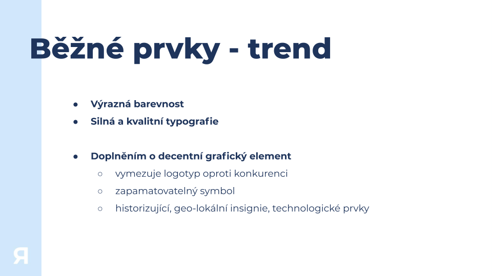 Slide titled 'Běžné prvky - trend' discussing common design elements like vibrant colors, strong typography, and decorative graphic elements including logos, memorable symbols, and historic, geo-local, technological insignia.