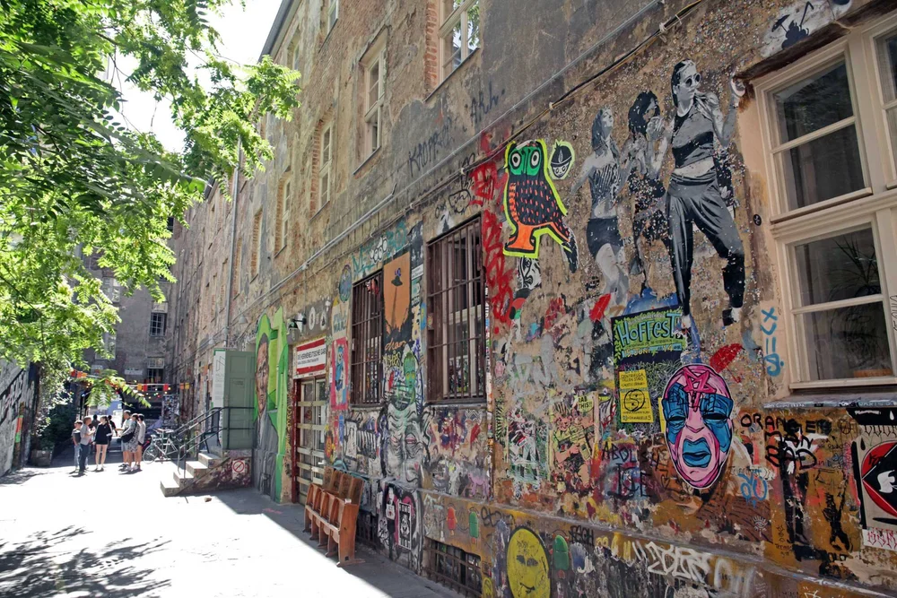 Street art courtyard alley in Berlin with murals and paste-ups