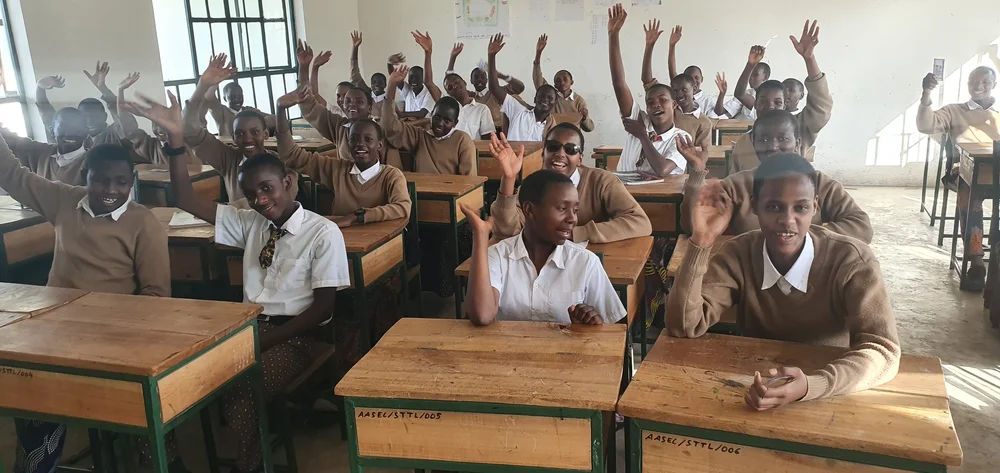 Students raising their hands in a classroom