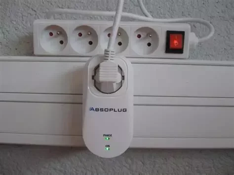 Prise électrique avec un filtre antiparasites ABSOLPUTC connecté, plusieurs prises électriques et un interrupteur marche/arrêt rouge.