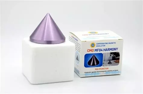 Un dispositif électronique avec un cône métallique violet sur un socle blanc, et sa boîte d'emballage indiquant 'CMO MF04 HARMONY'.