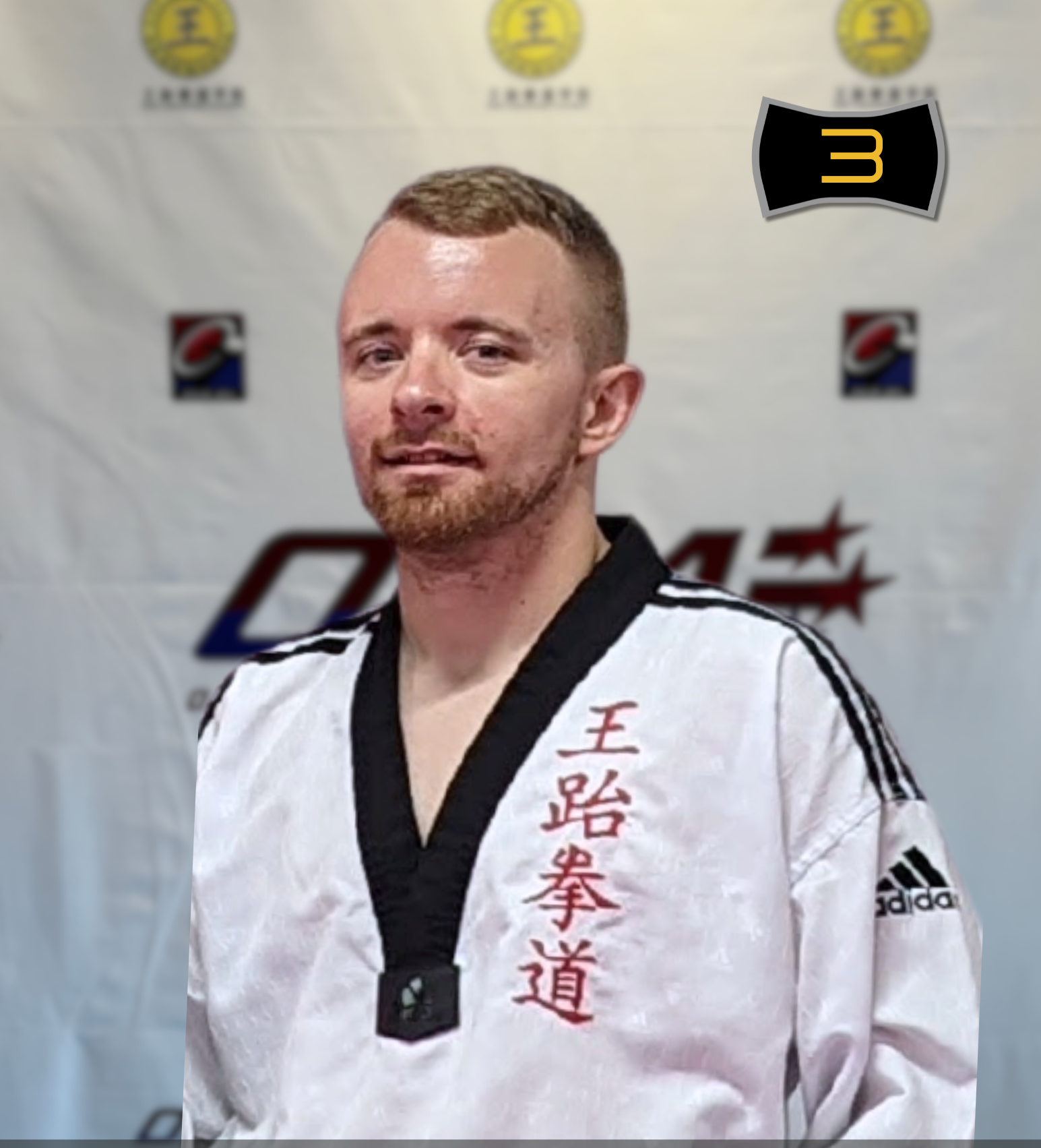 A man in a white taekwondo uniform with black trim and red Chinese characters on the front, standing in front of a banner with martial arts logos. He has short hair and a beard and is looking at the camera. Text overlay indicates he is an instructor at ONG Taekwondo Academy, Batch 4.