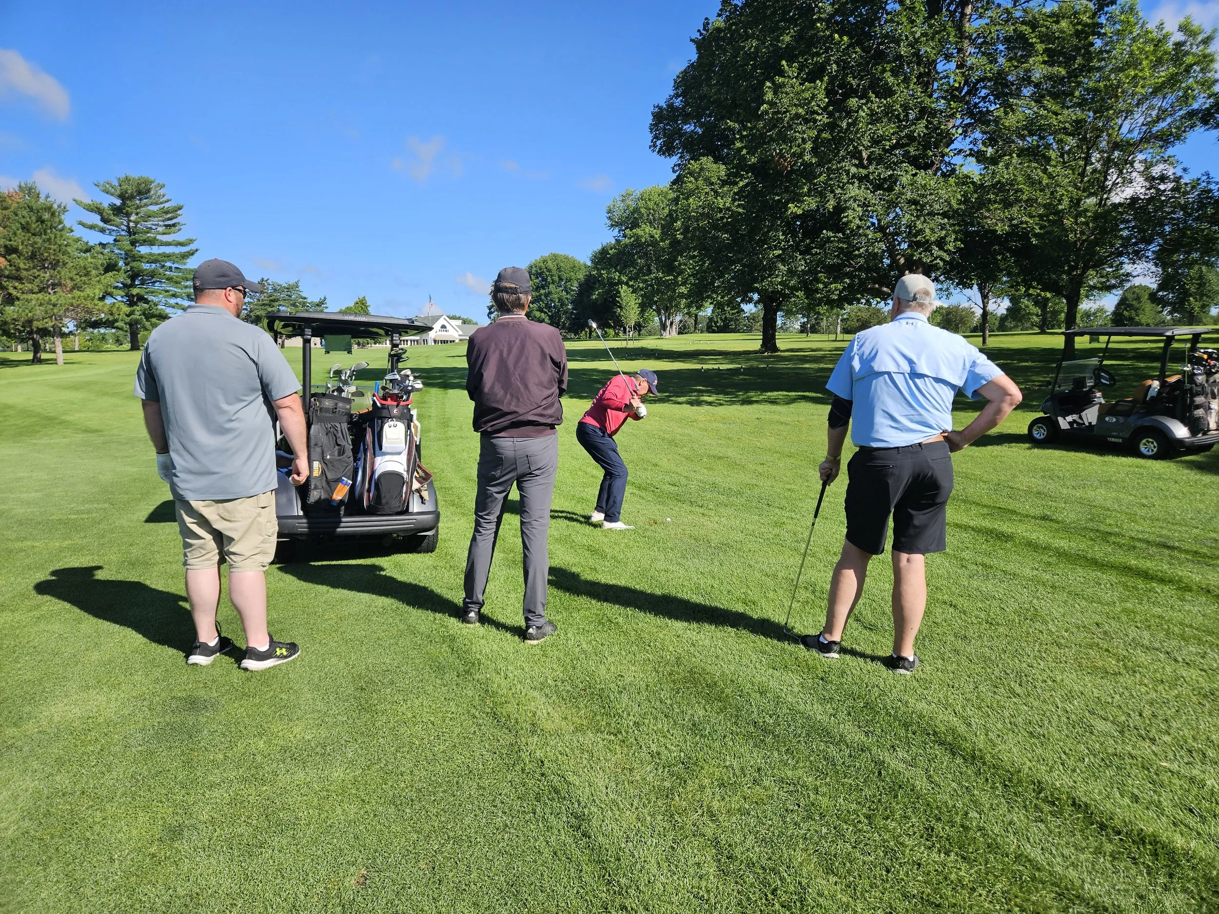 Scott taking his shot to get on the green with his team watching.