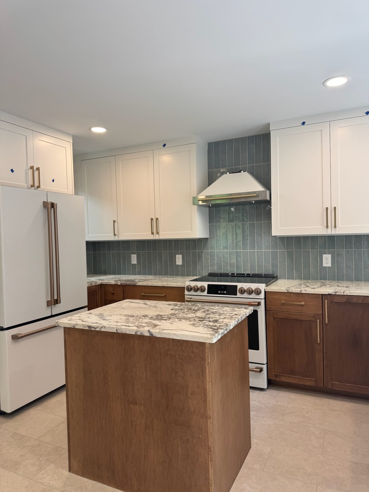 Two-tone kitchen with white shaker uppers, maple lower cabinets and island in a custom walnut stain, and a sage tile backsplash, Edina, MN