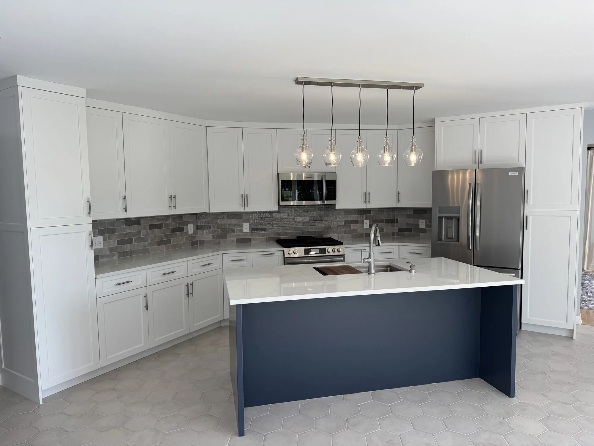 White painted shaker kitchen with a navy island and glass pendant lights, St. Paul, MN