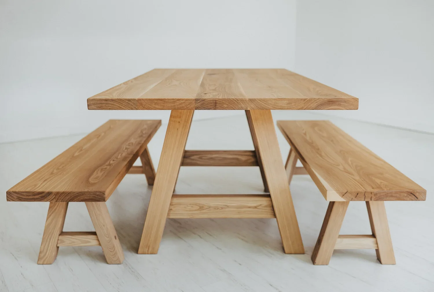 Wooden picnic table with two benches in a minimalist room