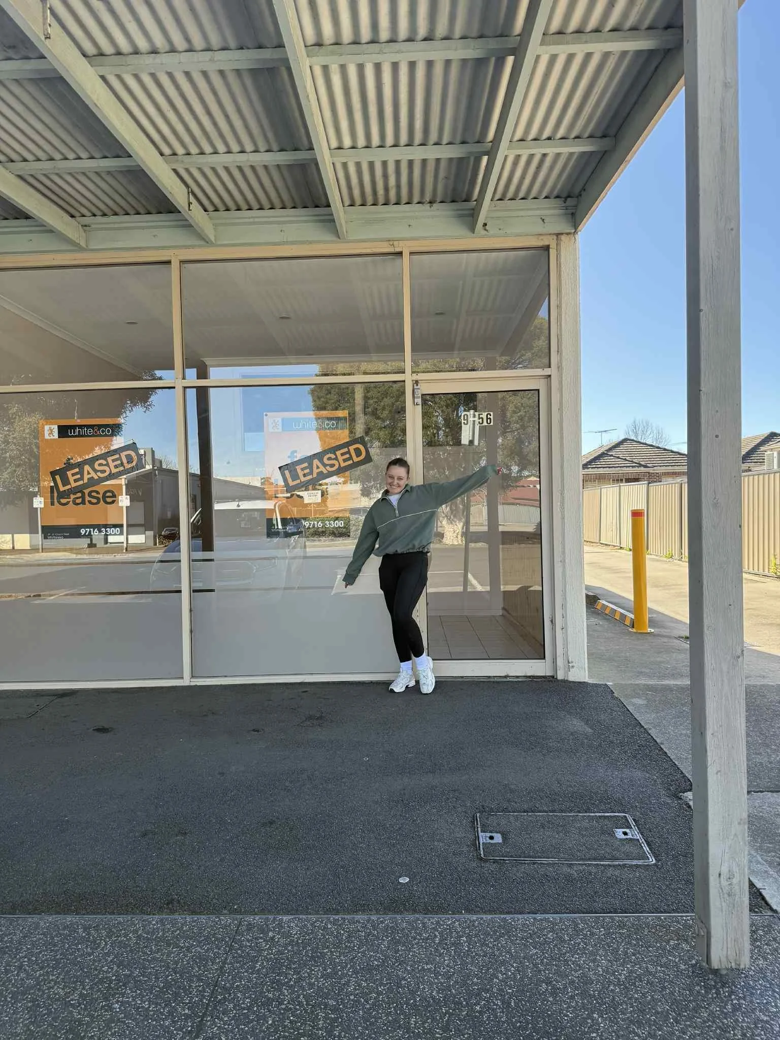 A woman standing in front of a glass storefront with