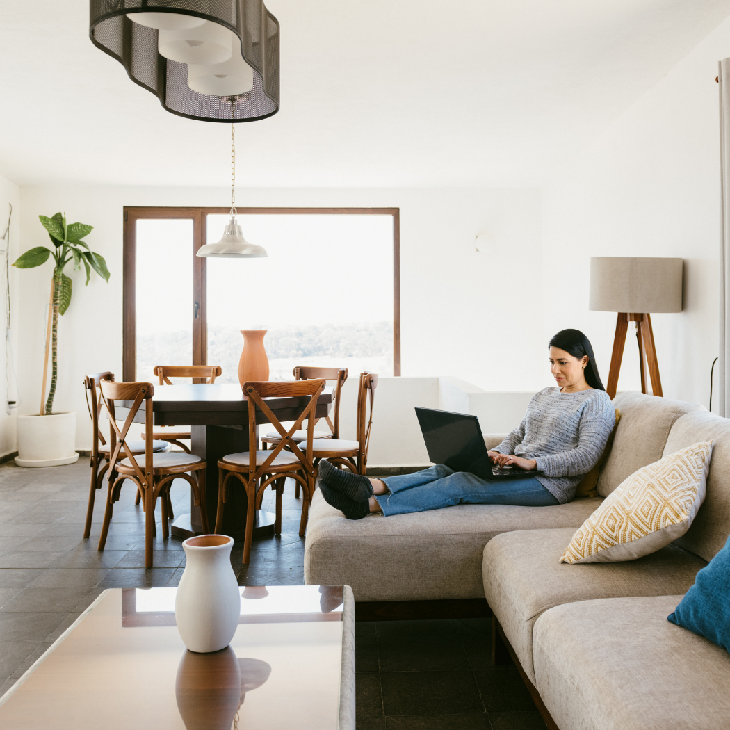woman at laptop on beige couch in sunny California
