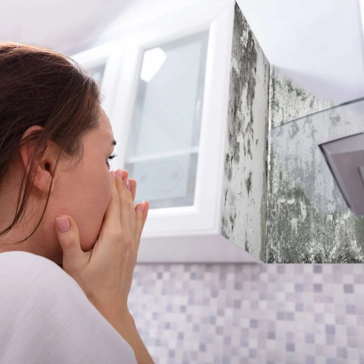 Woman looking at mold in her Sacramento rental property bathroom