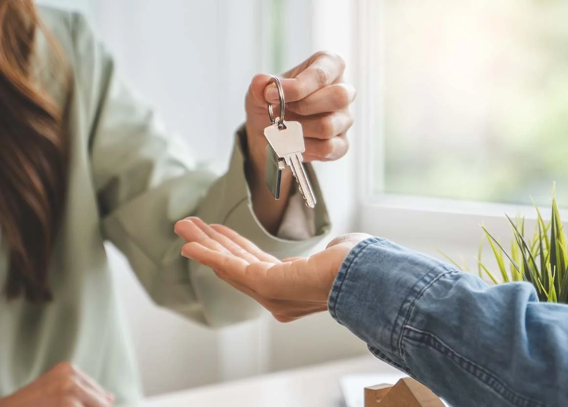 Image of a property owner giving keys to a rental property management company