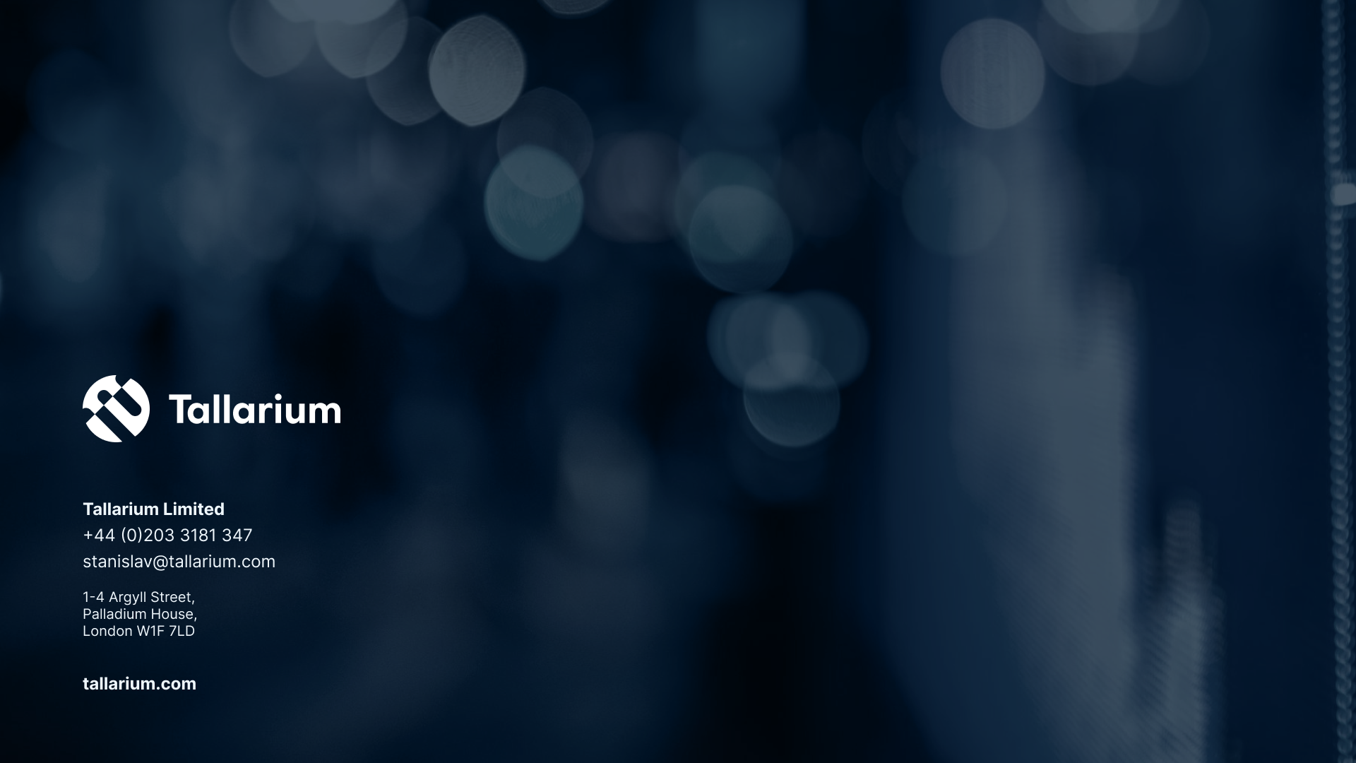 Business card for Tallarium Limited with contact information and company logo on a blurred dark background.