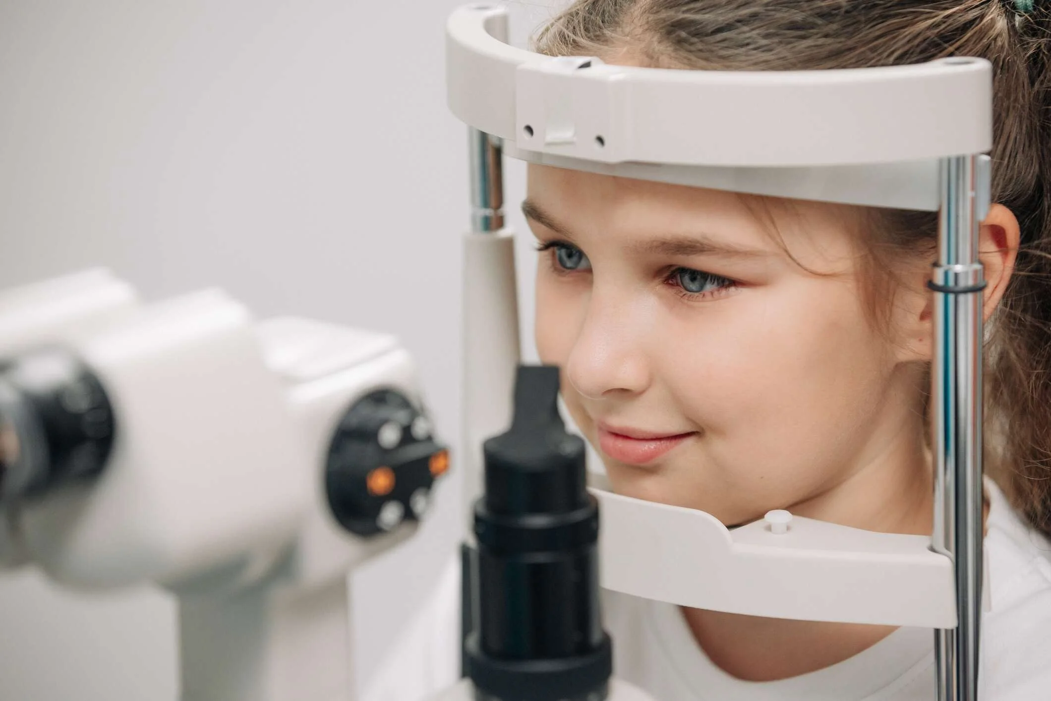 A young girl undergoes an eye test using modern diagnostic equipment.