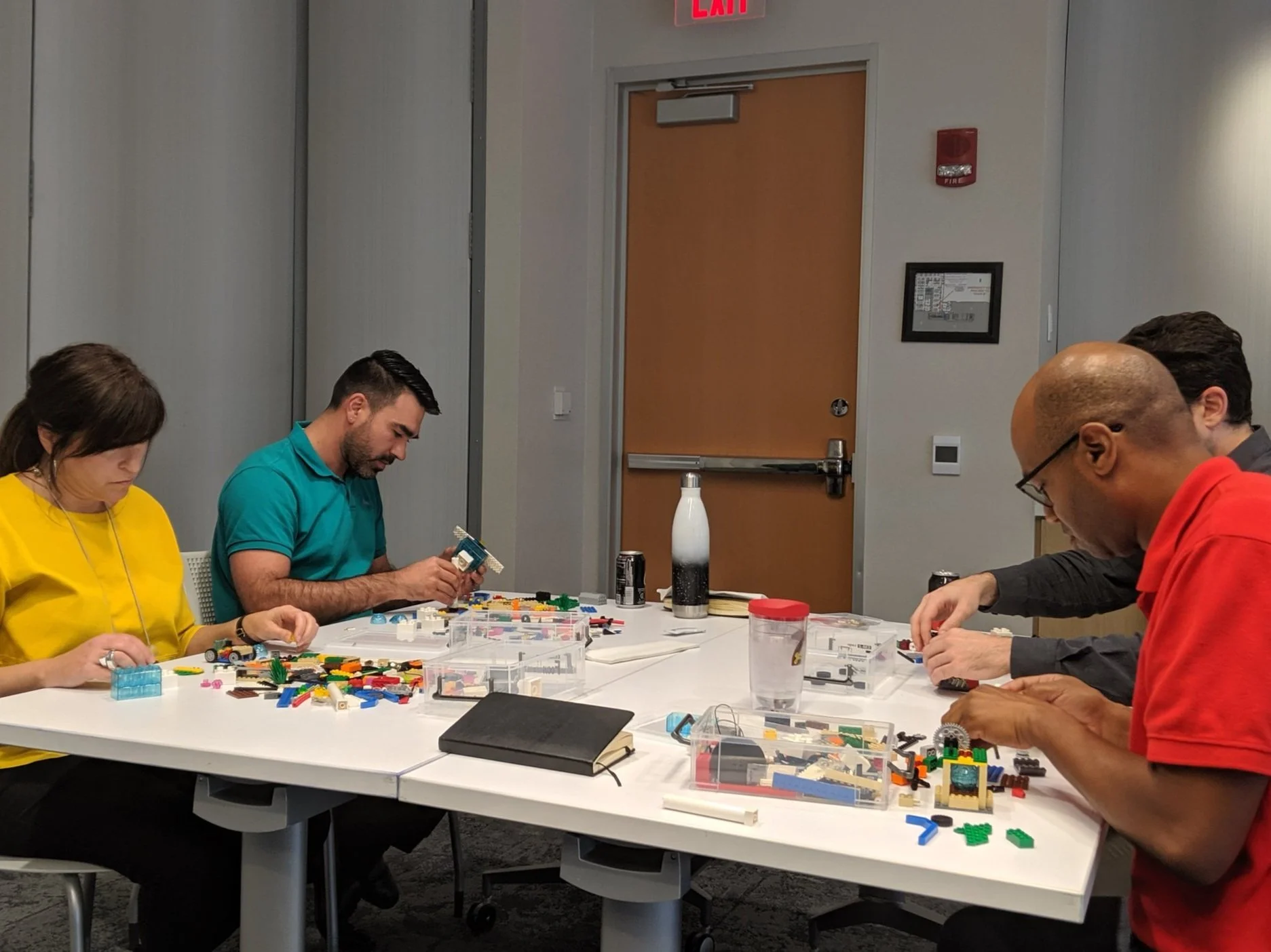 Team members collaborating through LEGO Serious Play methodology, building 3D models that represent their collective strengths and working dynamics