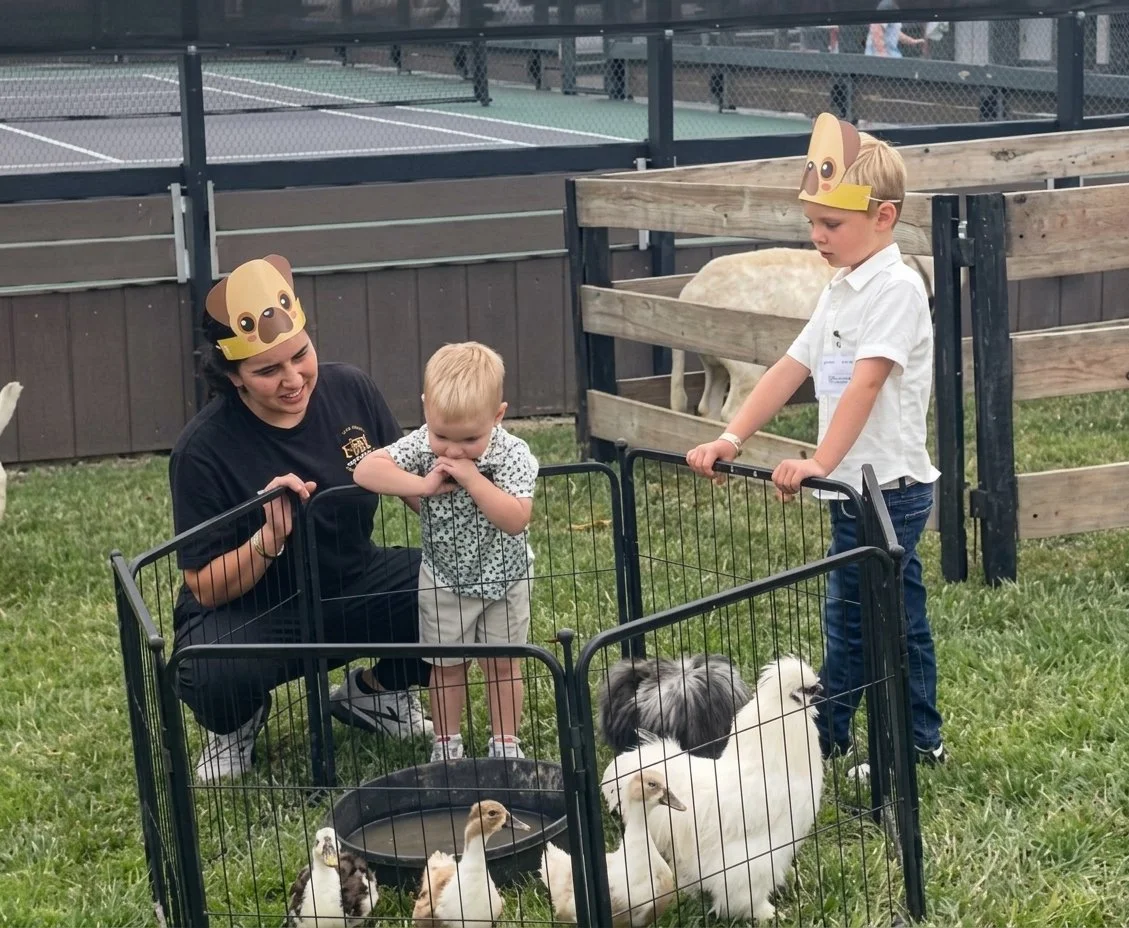 Trusted event childcare provider introducing children to a chicken while parents relax and enjoy the event in Cincinnati
