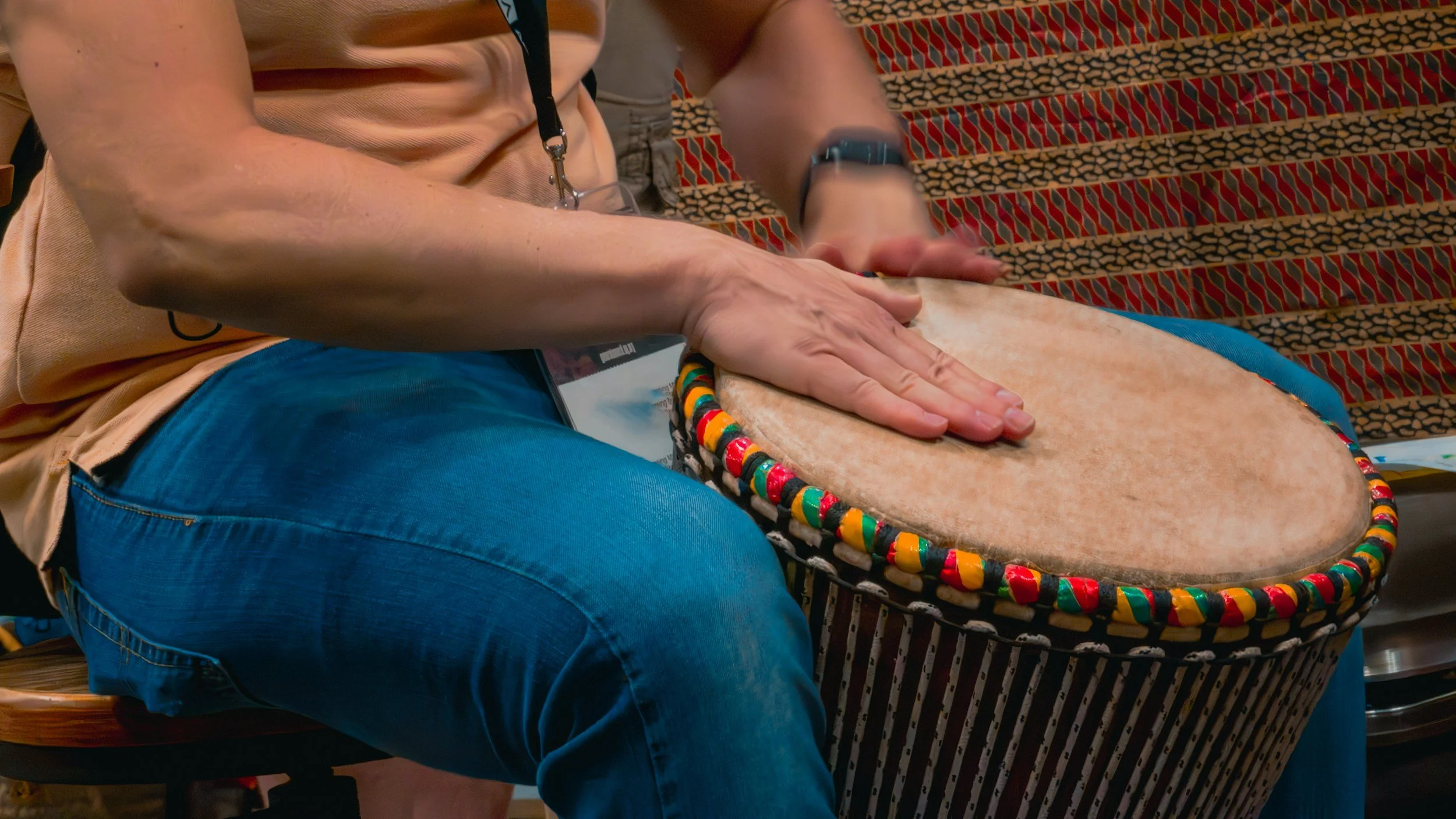 person playing a drum with their hands.