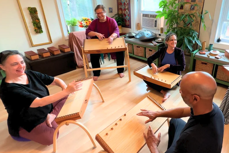a group of people play monochord instruments..