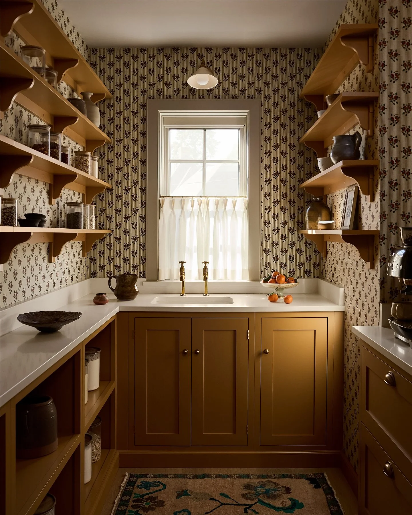 The cheeriest place to make your first cup of coffee. The scullery yellow cabinetry by @devolkitchens laid the foundation, add in wallpaper by @antoinettepoisson, some of our favorite vintage finds including the scatter rug sourced from our friends @