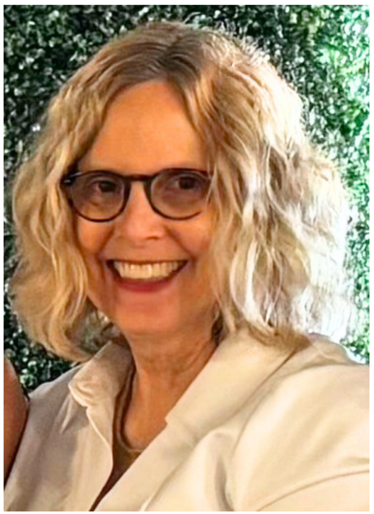 Picture of Mary Wilson with a warm smile wearing a white shirt and short wavy hair.
