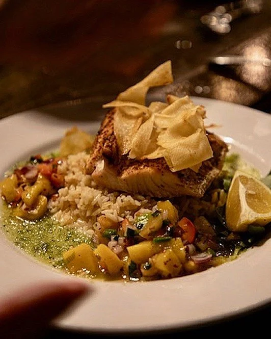 We haven&rsquo;t posted in a bit as we&rsquo;ve been hard at work on a new menu. One of our new favorites is this dish: local Mahi with coconut rice in a ginger cucumber coulis, garnished with Mango salsa, and topped with cassava chips. We&rsquo;d wr