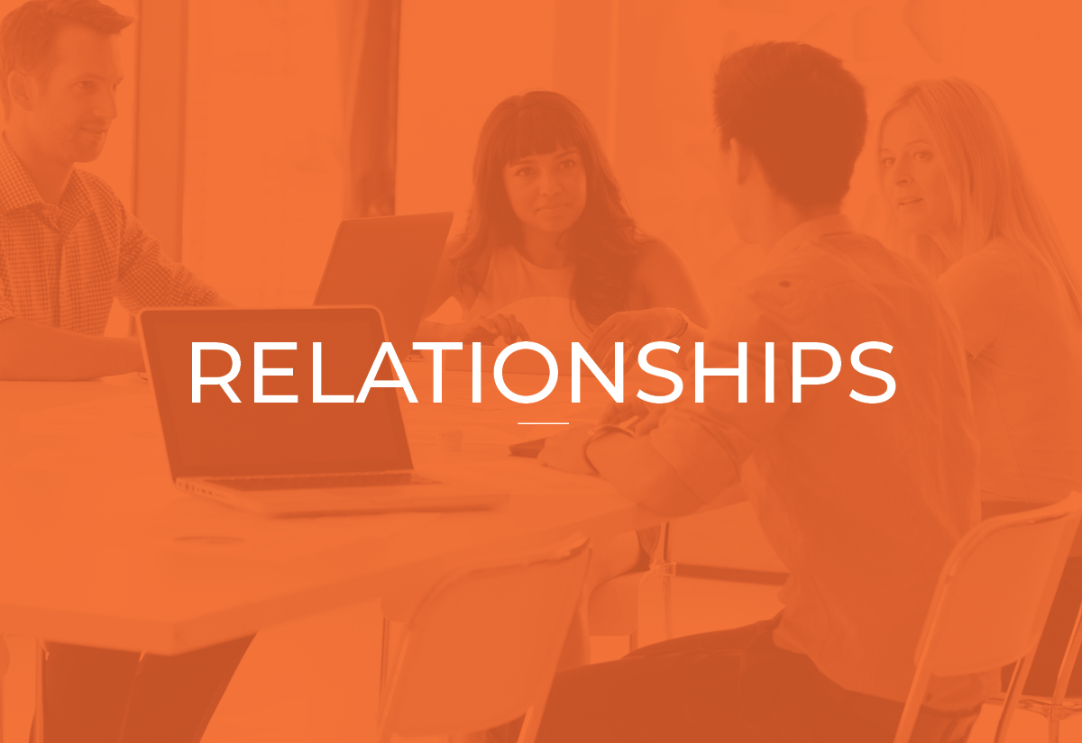 People sitting around a table having a discussion in a meeting room with laptops and a tablet, with the word 'Relationships' overlayed.