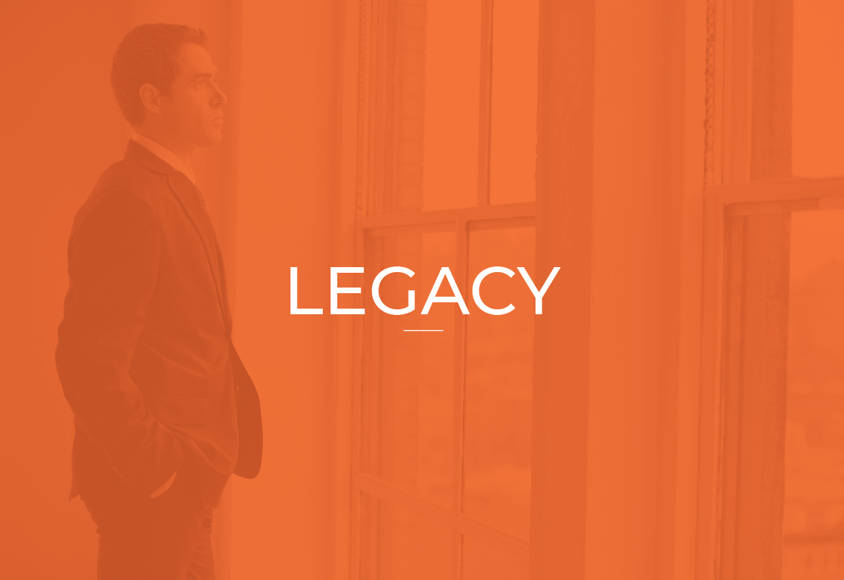 A man dressed in a suit stands in front of a large window, looking outside, with the word 'LEGACY' centered on the image.
