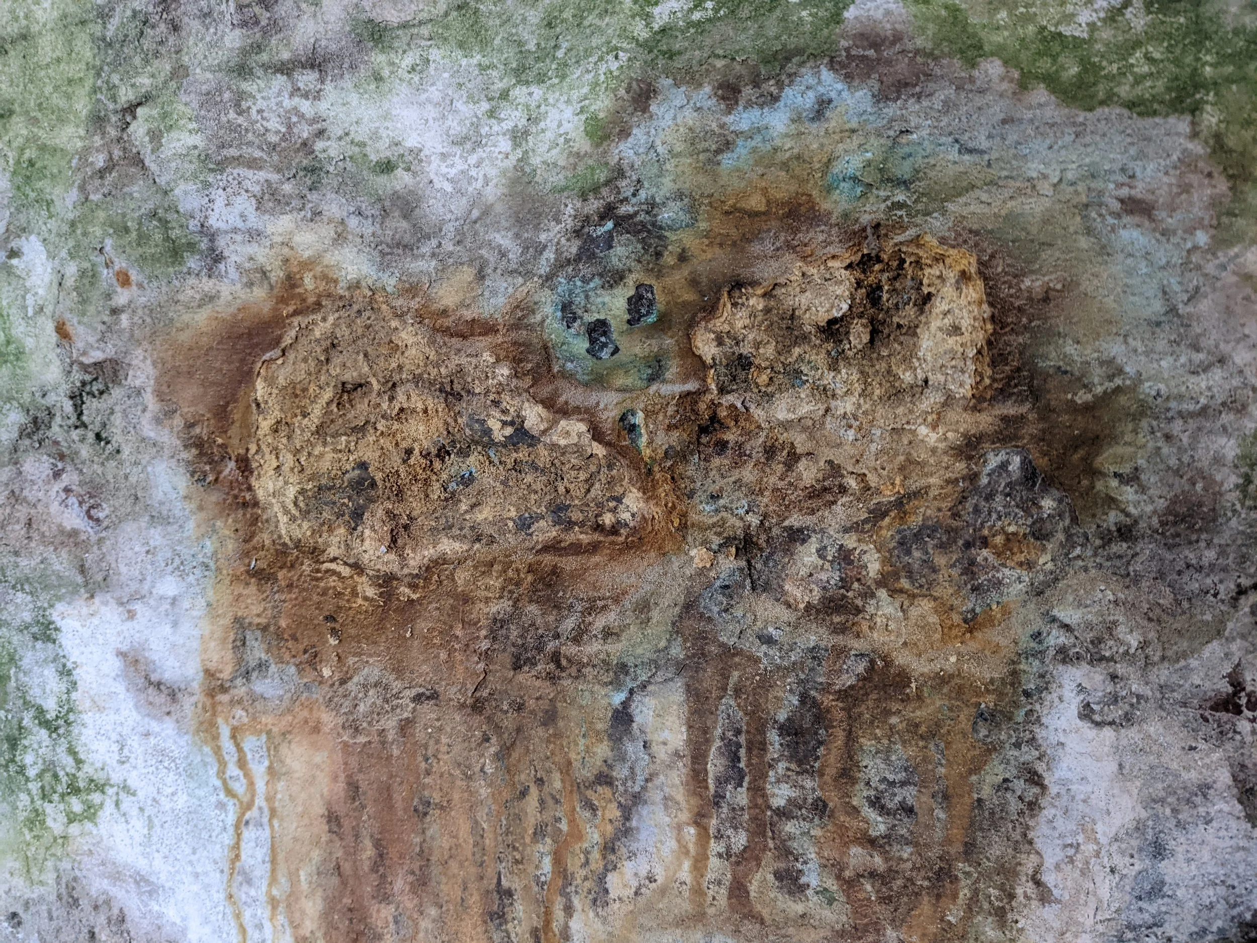 "Rusting", iron minerals  in the stone oxidising  due to non permeable surface covering.