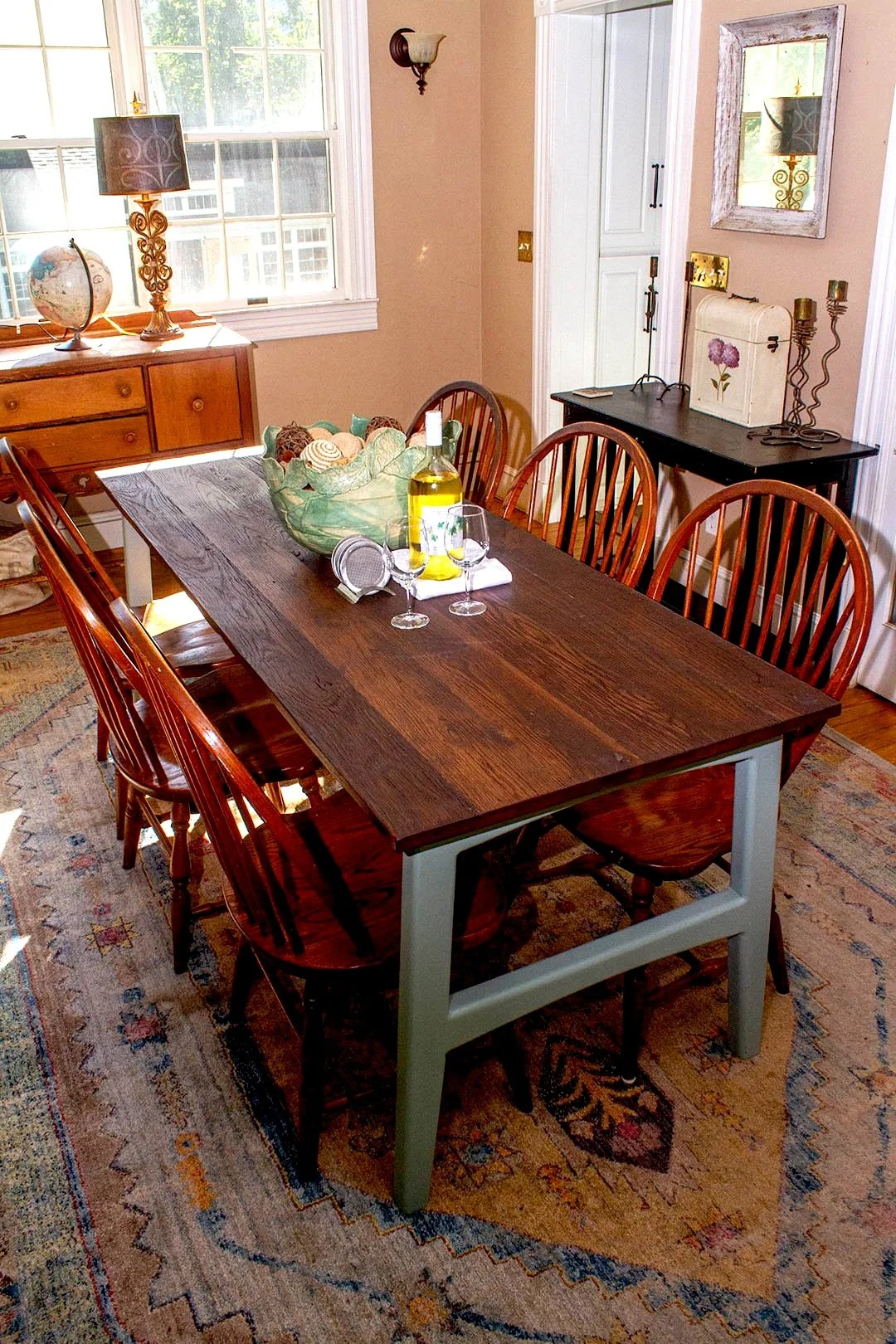 Custom reclaimed oak farmhouse dining table with painted green base, in a Baltimore dining room.