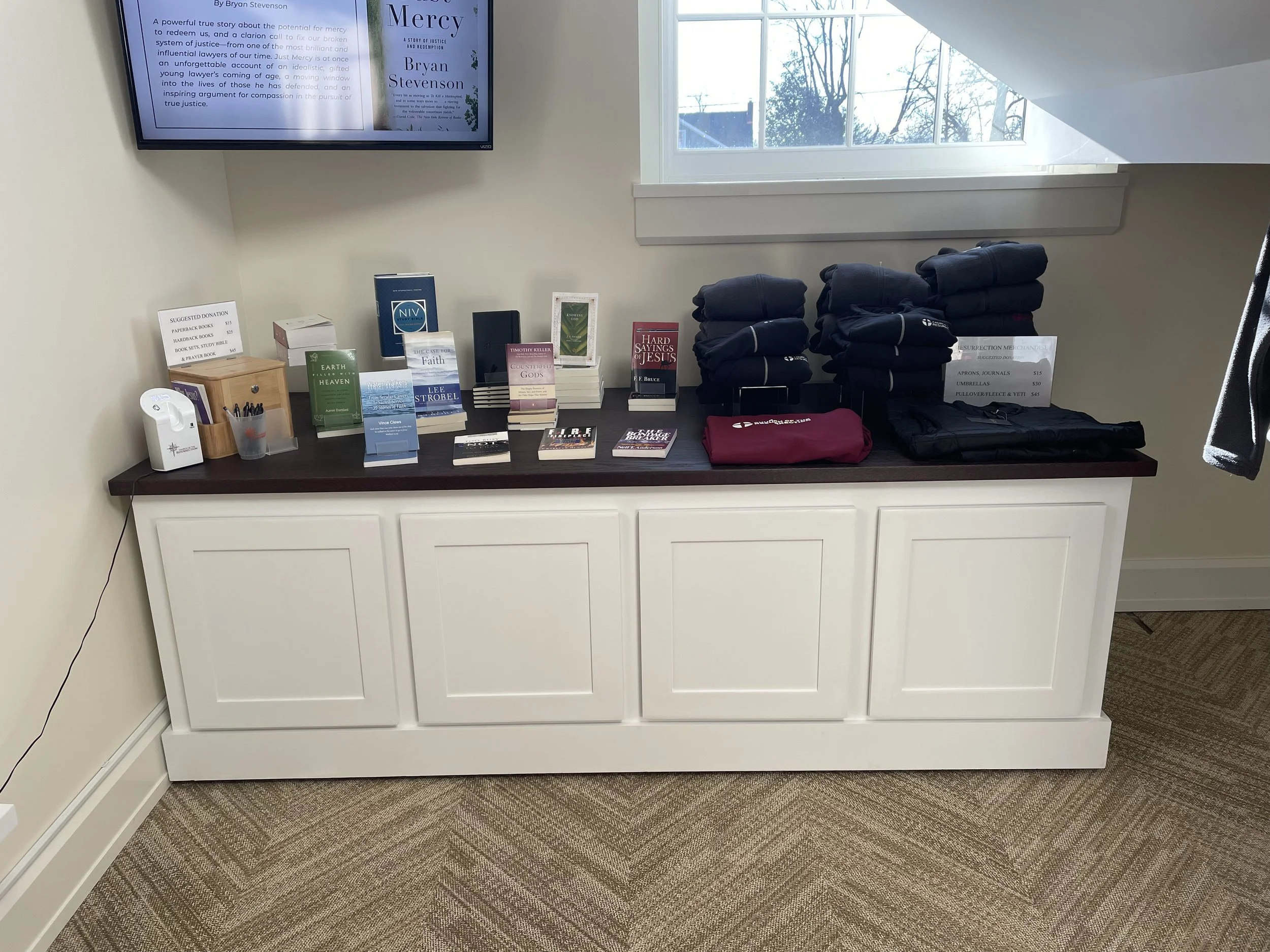 Custom cabinetry with raised-panel doors, used as a bookstore display counter in a Baltimore church.